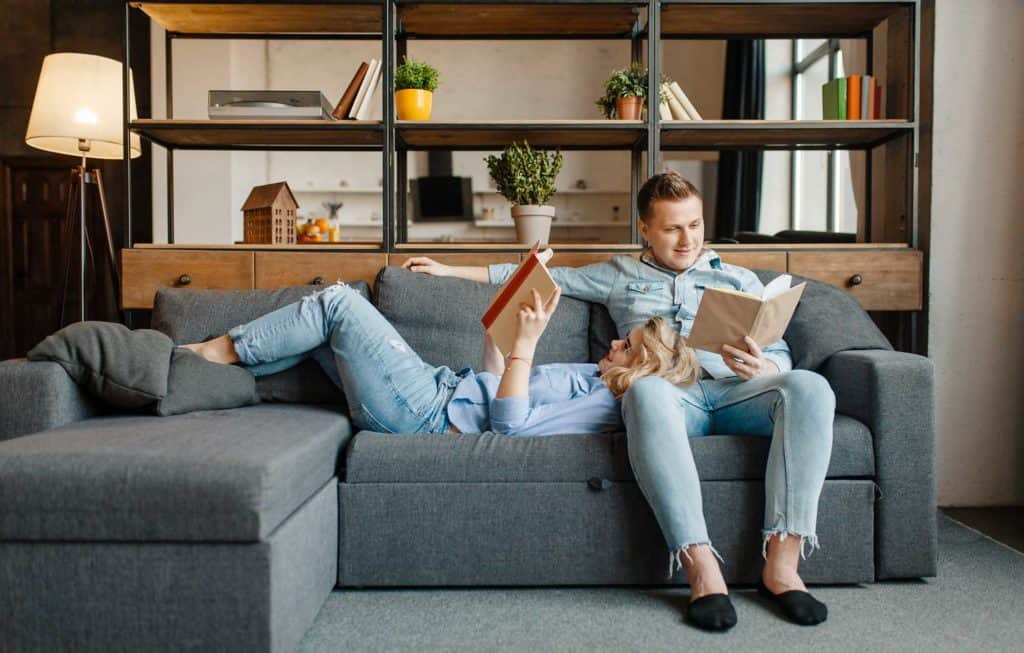 love couple resting on comfortable couch at home 5R78BFY